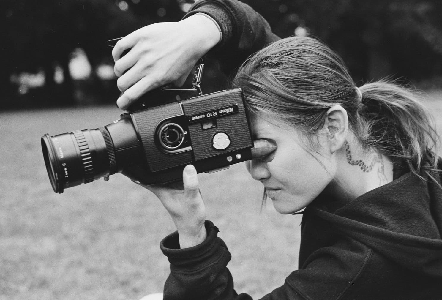 Kitty Wang holding a vintage film camera up to her eye